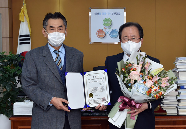 18일 오후 부산시교육청 교육감실에서 진행된 '2022 코로나 위기관리 대상 공모대회' 수여식에서 김석준 부산시교육감(사진 오른쪽)이 대상을 수여하고 있다. [사진=부산시교육청]